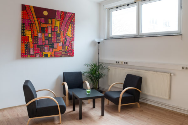 Wartebereich mit drei Sesseln und einem Tisch