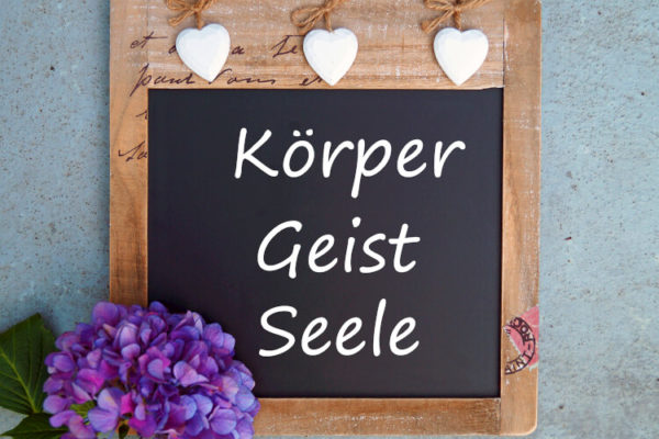 Schild mit Körper Geist Seele beschriftet